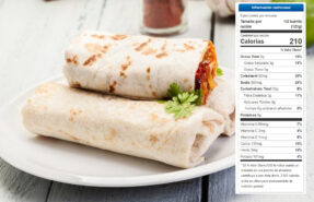 Un burrito de huevo y frijoles refritos, cortado por la mitad, mostrando sus capas de ingredientes frescos y saludables. Está presentado sobre un plato rústico o una tabla de madera, listo para ser disfrutado.