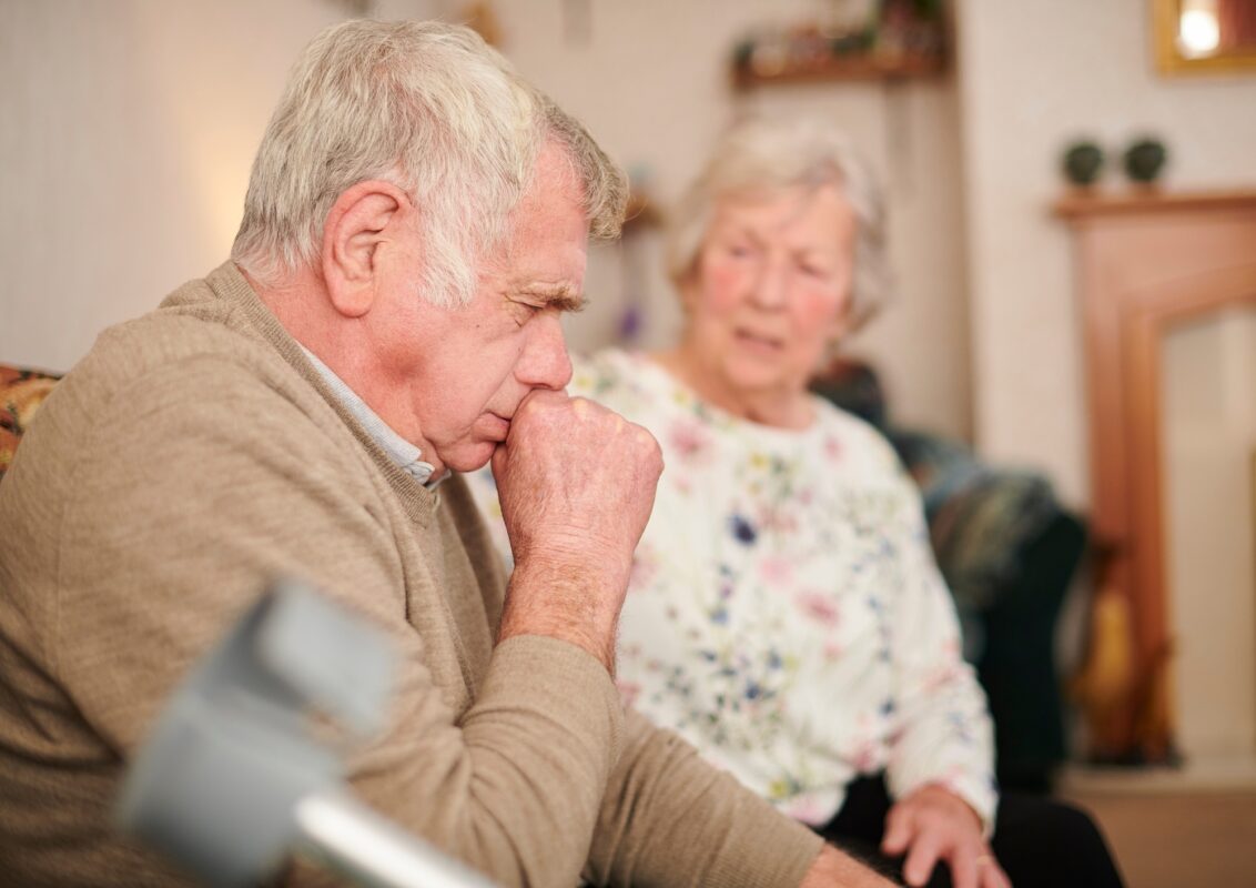 Un adulto mayor tosiendo en su hogar, sugiriendo posibles problemas de salud respiratoria y la importancia de los cuidados y la prevención.