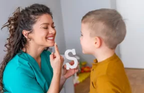 Niño recibiendo estimulación del lenguaje de un fonoaudiólogo en casa.